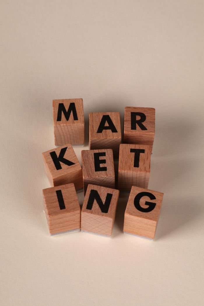 About Wooden blocks arranged to spell 'MARKETING' on a neutral background.