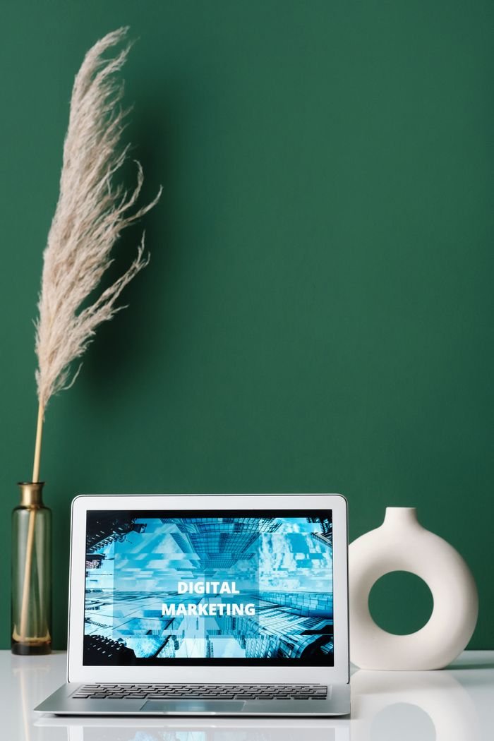 About Laptop displaying digital marketing on screen with decorative items on a desk.