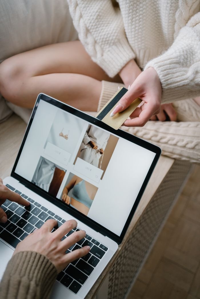 Home Person using a laptop for online shopping while holding a credit card.